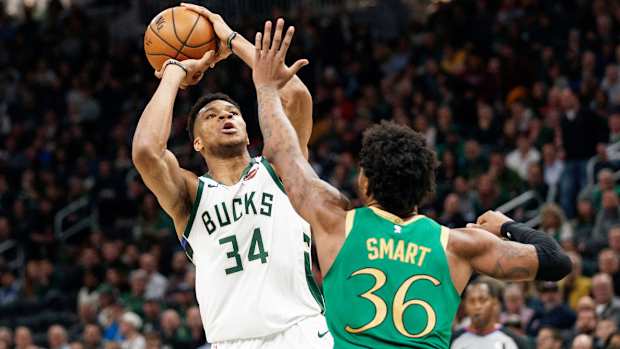 Giannis Antetokounmpo shoots the ball over Marcus Smart